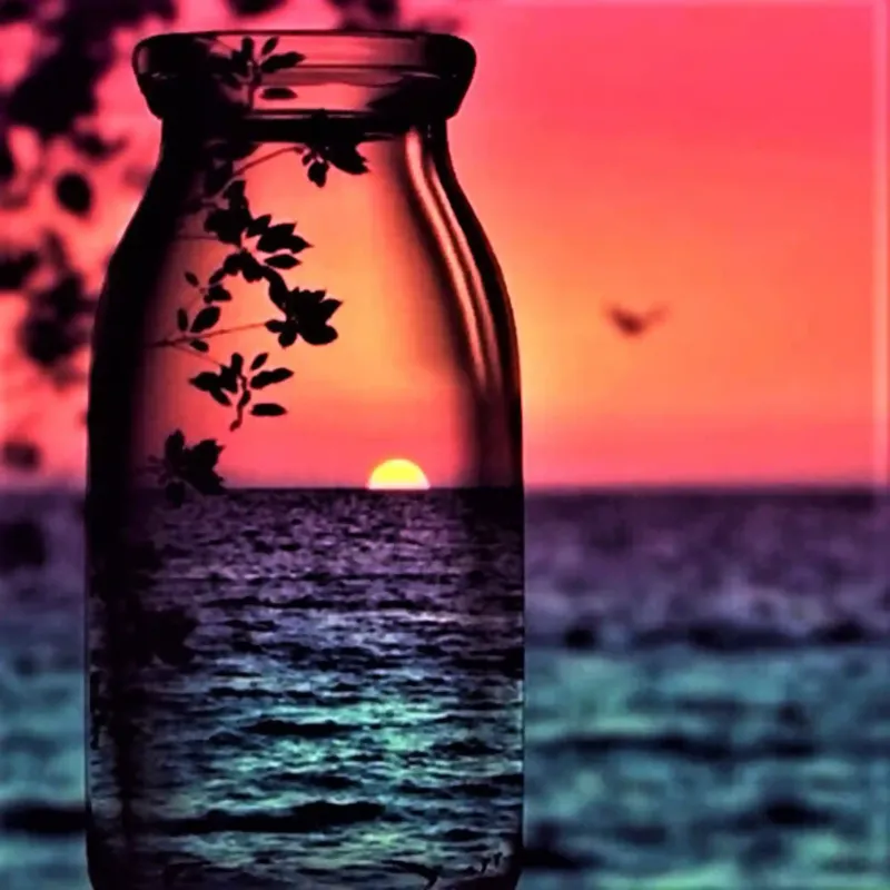 Diamond Painting Set mit rotem Sonnenuntergang in einer Glasflasche am Meer mit floralen Details
