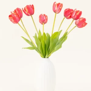 Der künstliche Blumenstrauß „French Tulip Red“ aus Seide ist in einer weißen Keramikvase arrangiert, mit acht roten und gelben Tulpen mit grünen Blättern vor einem schlichten hellen Hintergrund.