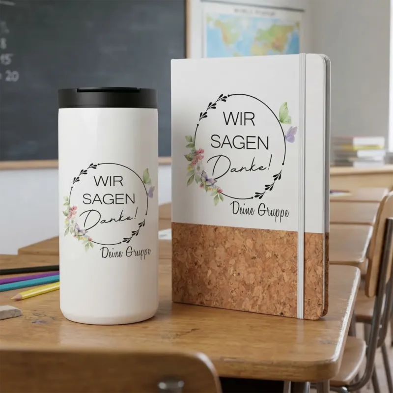 Weißer Becher und Notizbuch mit floralem Design.
