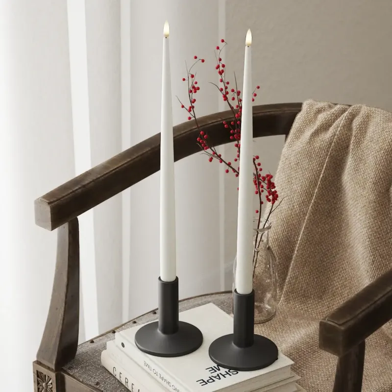 Zwei Nordic Flame LED Stabkerzen mit 3D-Flamme auf Stuhl, gemütliche Deko, Indoor Winter.