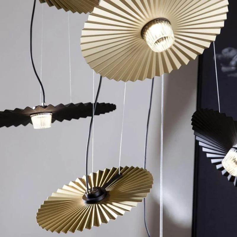Karman Gonzaga LED Außen-Hängeleuchte IP65 mit gewelltem Leuchtenschirm in Gold und Schwarz.