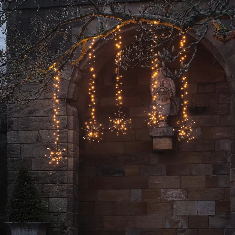 Warmweiße LED-Starburst-Hängedeko für Bäume außen mit Blinkeffekt am Baum