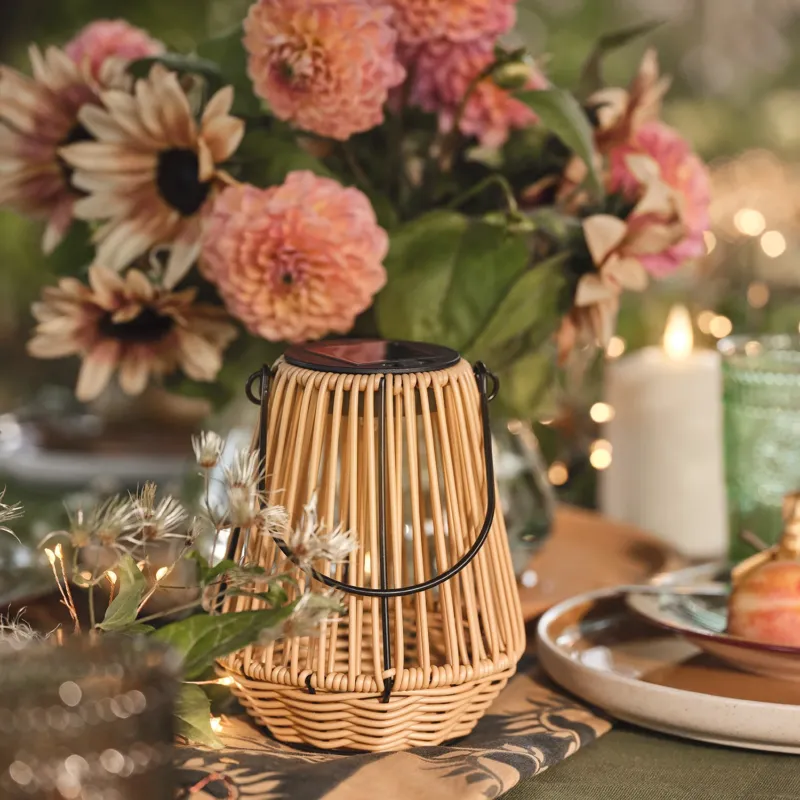 Hygge Solar-Laterne in Rattanoptik mit warmweißer LED auf Frühlingstisch