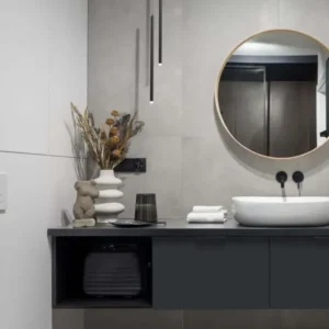 Moderne Badezimmeransicht mit Trimle LED Pendelleuchte H 70cm Ø 2,5cm 3000K über Waschbecken und stilvollen Accessoires.