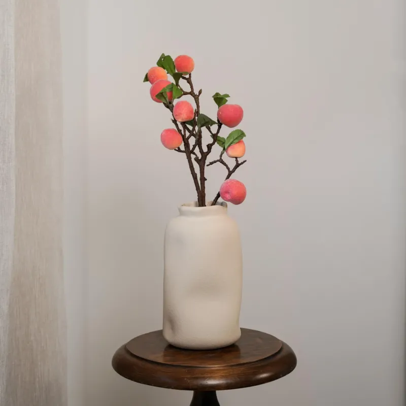 Branche de pêches artificielle, vue des tiges à l'unité dans un vase élégant - Flowrette