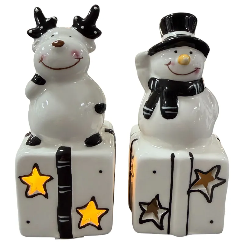 Keramik-Rentier und Keramik-Schneemann stehen jeweils auf einem Geschenk mit sternförmigen Aussparungen und LED-Beleuchtung.