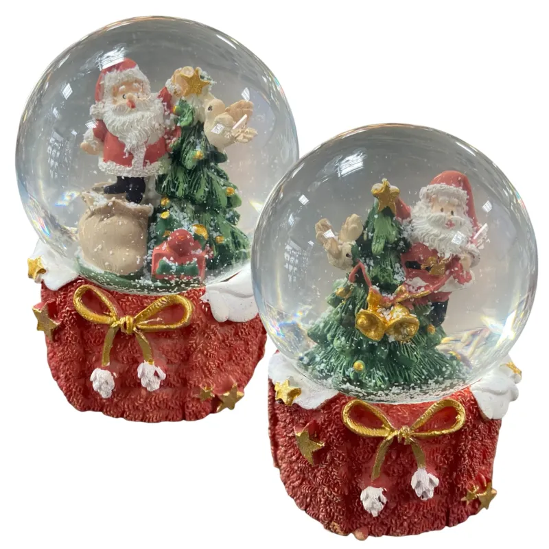 Kleine Schneekugeln mit Weihnachtsmannfigur, Tannenbaum und Geschenksack auf rotem Sockel mit goldener Schleife.