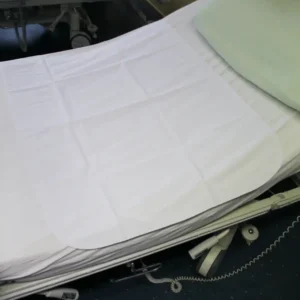 Pflegebett mit ausgelegter Medi-Inn Bettschutzauflage 70 × 100 cm