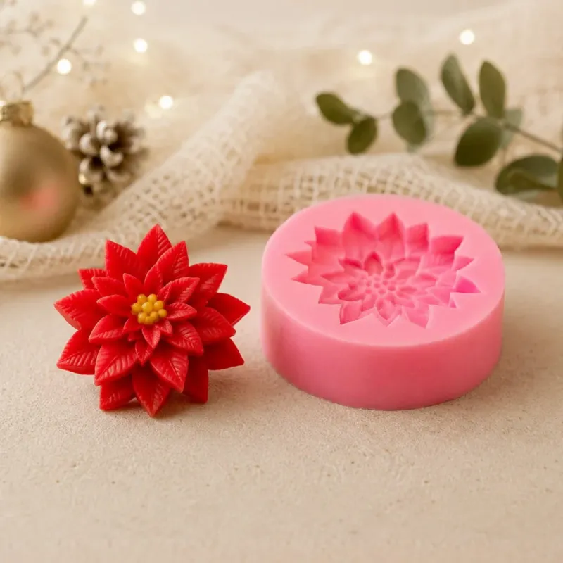 Décoration poinsettia rouge démoulée à côté de son moule en silicone rose