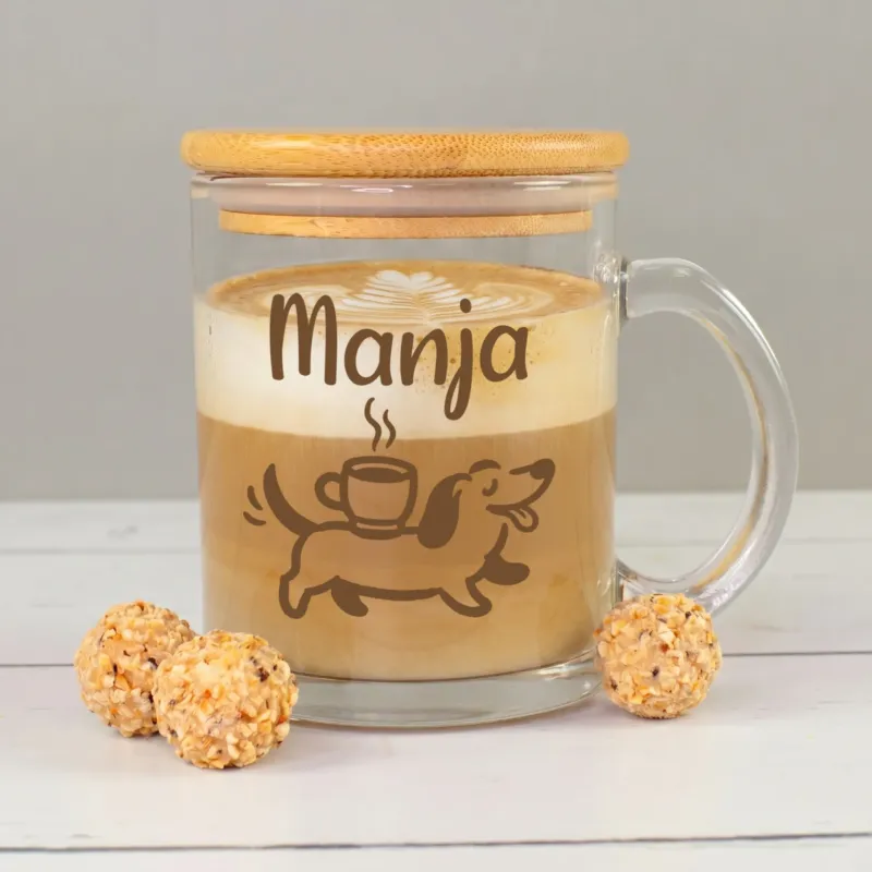 Glastasse mit Bambusdeckel und Namen Manja, gefüllt mit Kaffee und Milchschaum