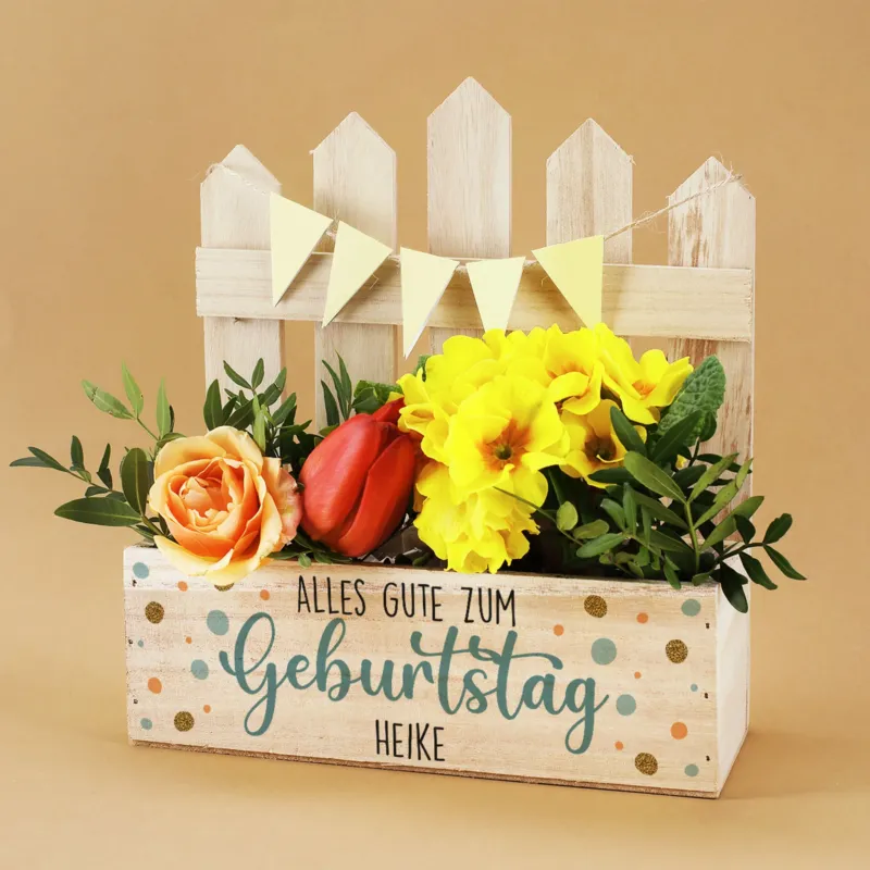 Pflanzkiste zum Geburtstag mit Konfetti und Name bedruckt, mit Dekorationsbeispiel mit Blume