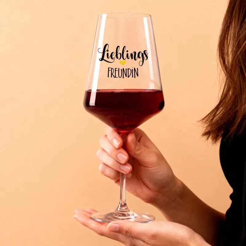 Personalisierbares Weinglas „Lieblings Freundin“ mit Herzmotiv, in der Hand gehalten