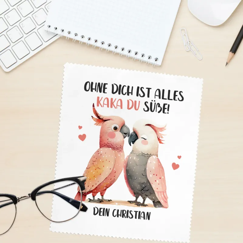 Kakadu-Brillenputztuch mit Herzchen und Spruch „Ohne dich ist alles Kaka du süße! Dein Christian“ auf Bürotisch mit Brille, personalisierbar