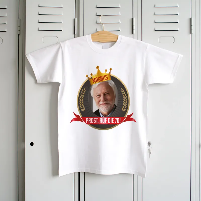 Personalisiertes weißes Herren-T-Shirt mit Geburtstagsmotiv, Foto, Krone und rotem Banner, hängend an einem Kleiderbügel.