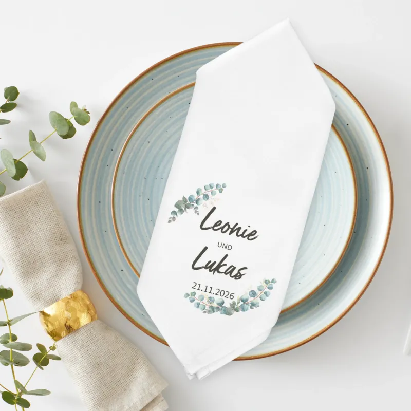 Stoffserviette Hochzeit mit Eukalyptuskranz personalisiert mit Namen und Datum auf Teller dekoriert