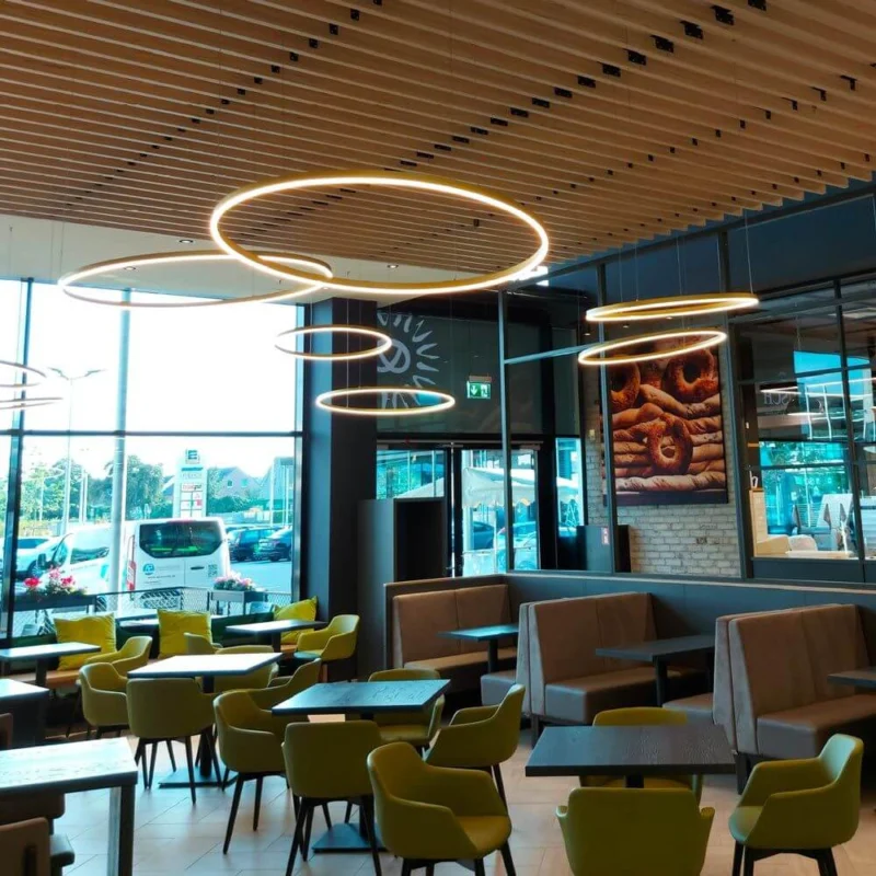 s.luce LED Ring Hängeleuchte Ø 120cm in modernem Restaurant mit stilvollem Interieur und großen Fenstern.