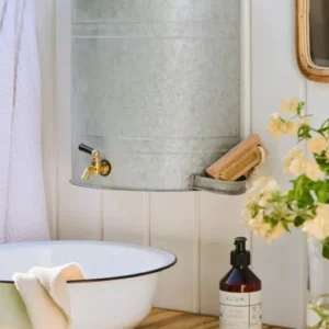 Detailaufnahme Wand-Wasserbehälter aus Metall mit Messing Wasserhahn und integrierter Seifenablage.